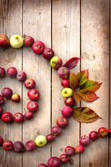 Autumn apples and leaves on wooden table with grunge texture