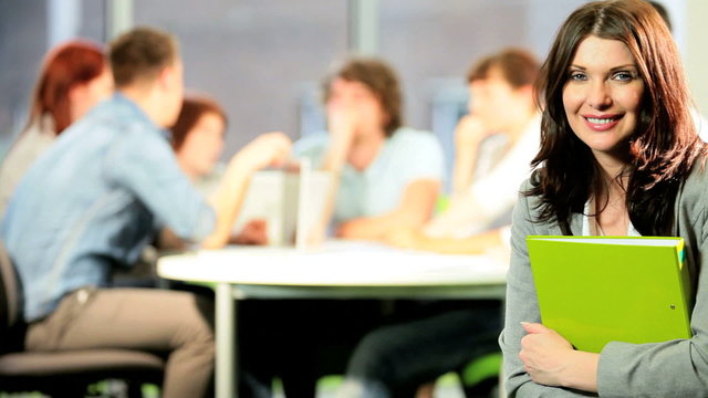 Portrait of brunette tutor learning students in classroom