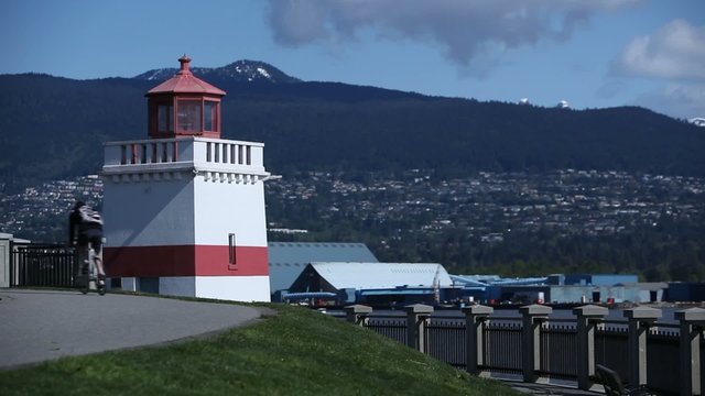 A man on a bicycle passes the Lighthouse in Stanley Park