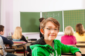 Education - teacher with pupil in school teaching
