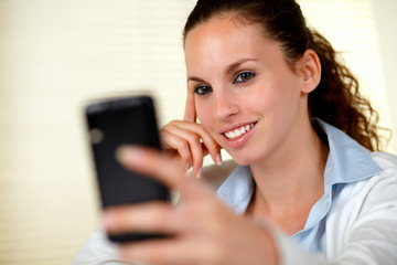 Lovely young woman reading a message on cellphone