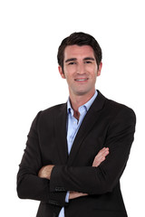 Upbeat businessman with arms folded