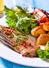 Grilled steak with baked potatoes and salad