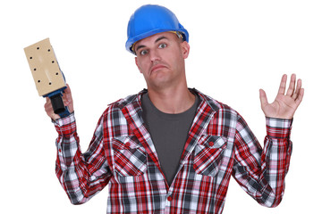 Construction worker holding up a sander