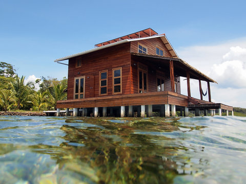 Tropical house on stilts over water of the Caribbean sea