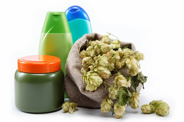 Bottles of shampoo and a bag of hops isolated on a white backgro