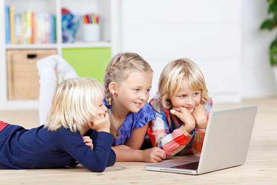 drei mädchen mit laptop im kinderzimmer
