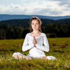 Woman exercising yoga against brick wall
