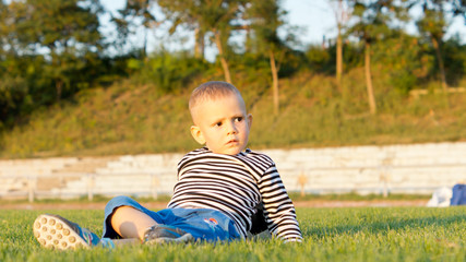 Little boy lying on green grass