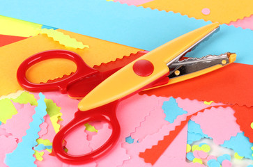 Colorful zigzag scissors on color paper background