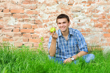 Smiling young man with green apple