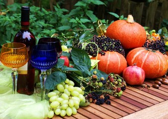 Tisch, gedeckt mit Wein, Obst und Gemüse