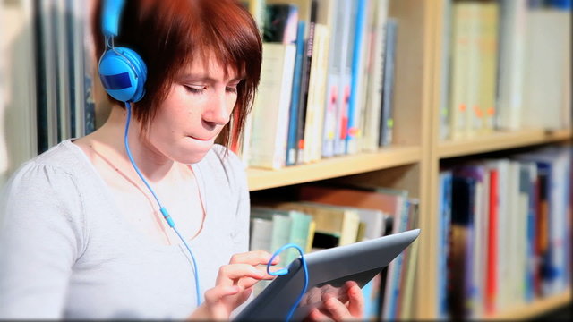 Female student study and listening to mp3 player 