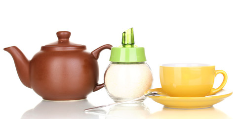 Yellow cup with saucer and teapot isolated on white