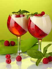 fruit jelly with berries in glasses on green background