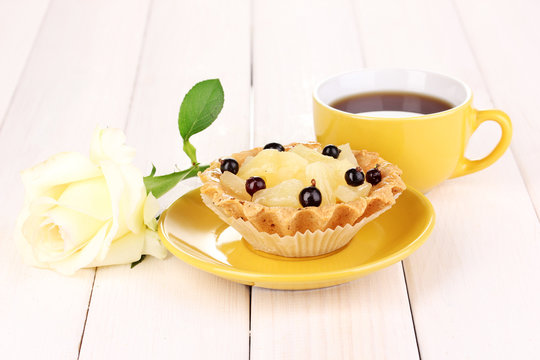 sweet cake with cup of tea on wooden background