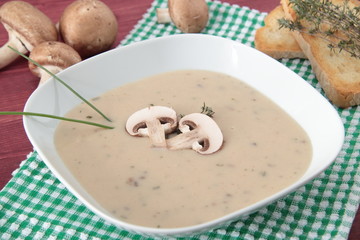 crema di funghi su tavolo con funghi e pane tostato