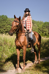 Obraz premium Cowgirl riding a bay horse