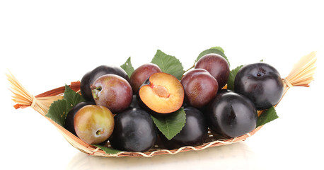 Rip plums on basket isolated on white