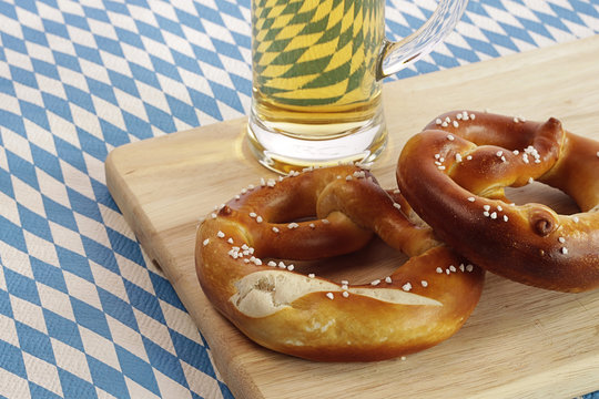 Zwei Brezn mit Bier auf bayerischer Flagge