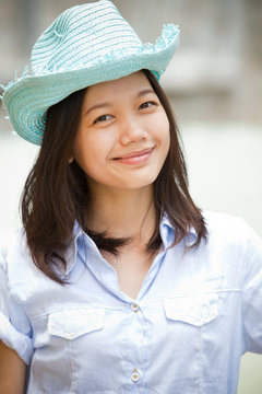 face of woman wearing cowboy hat and smile