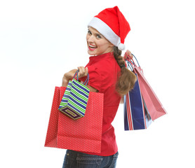 Young woman in Christmas hat with shopping bags looking out