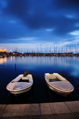 Fototapeta premium Two white boats floating on water at blue sky