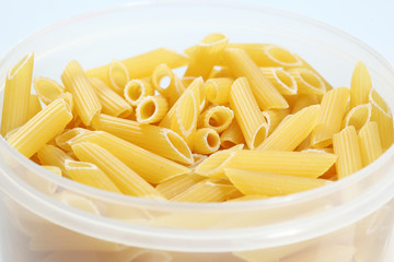 Uncooked penne pasta in plastic holder