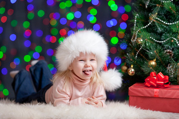 Fototapeta na wymiar funny baby w Santa Claus kapelusz na jasnym tle świąteczne