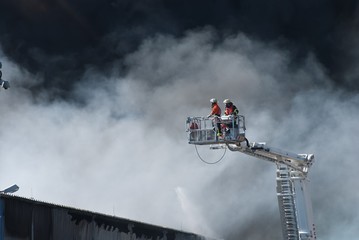Feuerwehr auf langer Leiter im Einsatz bei Großbrand in Industriegebiet, Niedersachsen,...