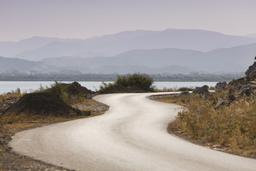 Obraz premium snake road to the mountain along the lake