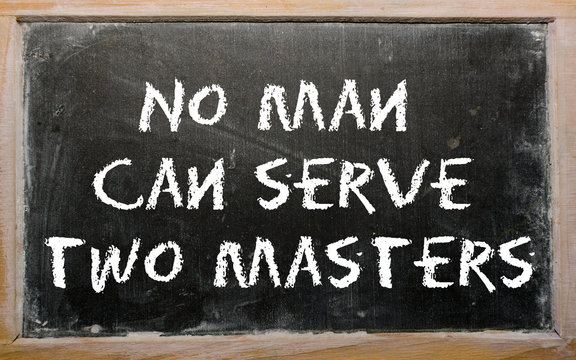 Proverb "No man can serve two masters" written on a blackboard