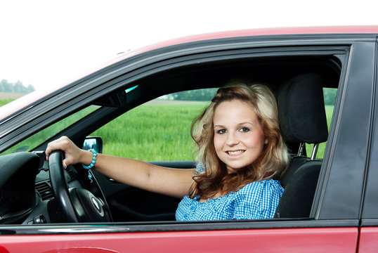 Junge h&uuml;bsche Frau im Auto gl&uuml;cklich