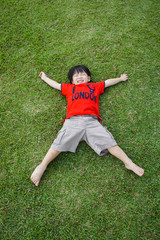 Boy laying on the green grass