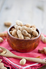 A wooden bowl full of peanuts