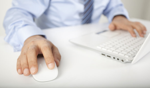Image of male hand touching computer mouse and keyboard
