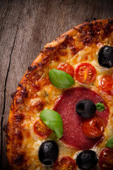 Tasty Italian pizza on wooden background