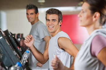 Men And Woman Running On Treadmill