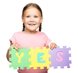 Cute little girl is holding Yes slogan