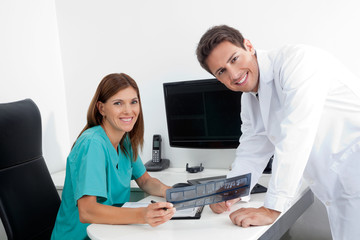 Obraz na płótnie Canvas Szczęśliwa Dentysta i asystent z X-Ray Raportu