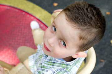 little boy spinning on the roundabout