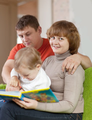 parents with child looks the book