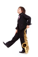 Naklejka premium Portrait of handsome kid posing in studio with saxophone