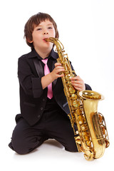 Obraz premium Portrait of handsome kid posing in studio with saxophone