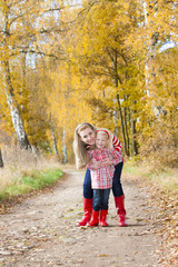 mother with her daughter in autumnal alley