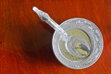 Water bowl made ​​of silver on the wooden bacground