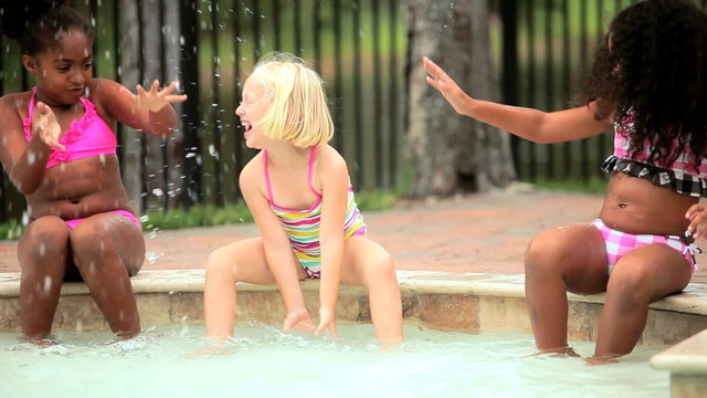 Multi ethnic happy girls enjoying activity in swimming pool
