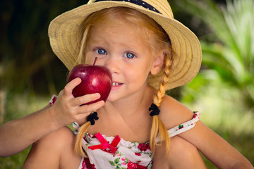 Девочка в шляпе с красным яблоком