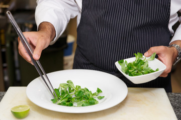 Chef is mixing salad