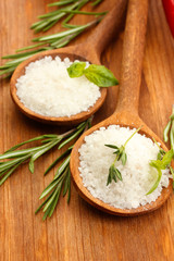 salt in spoons with fresh basil, thyme and rosemary isolated